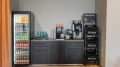 Getränke- und Kaffeeecke mit Getränkekühlschrank, Kaffeemaschinen, Wasserstation und Fritz-Kola-Kisten.