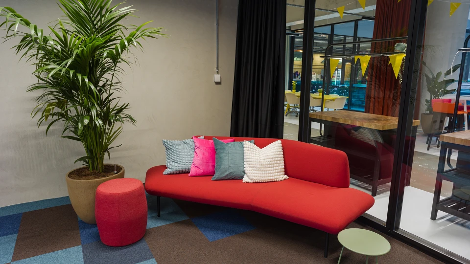 Detailansicht der Elektro Stage mit bunten Sesseln, Pflanzen und Glastüren.