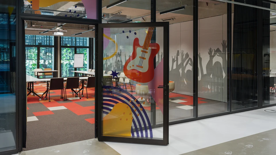 Eingangsbereich zur Rock Stage mit aufgedruckter Gitarre auf der Tür und Blick auf rote Teppichgestaltung und Wandgrafiken.