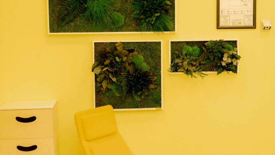 Unique interior design at Smartvillage Bogenhausen: A creative workspace with ergonomic furnishings, nature-inspired wall designs, and harmonious yellow color schemes that enhance an inspiring work atmosphere.