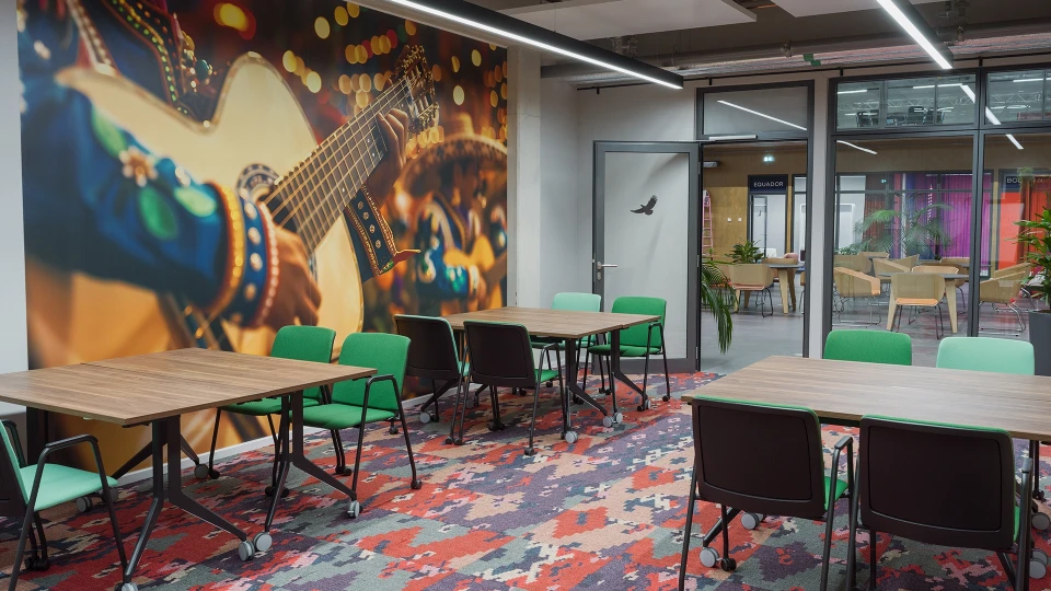 Moderner Meetingraum mit tropischen Pflanzen und großem Wandbild einer Gitarre im Smartvillage Köln-Mülheim, Raum Kolumbien Cali