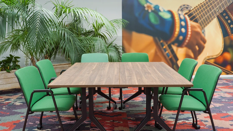 Konferenzraum Kolumbien Cali mit Flipchart, grünem Interieur und Teppich im folkloristischen Stil