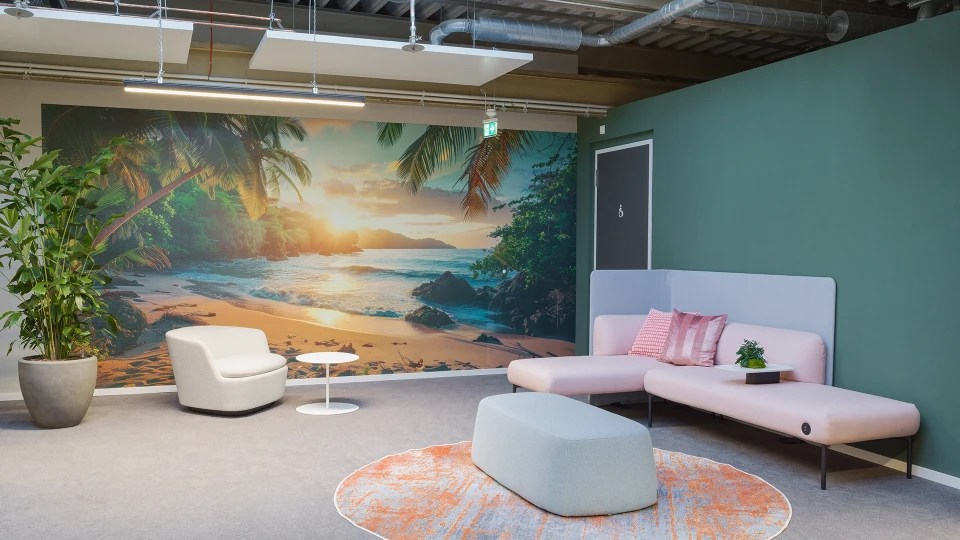 Sitzecke mit Strandmotiv-Wandbild, rosafarbenen Sofas und beigem Sessel, inspiriert vom tropischen Costa Rica.