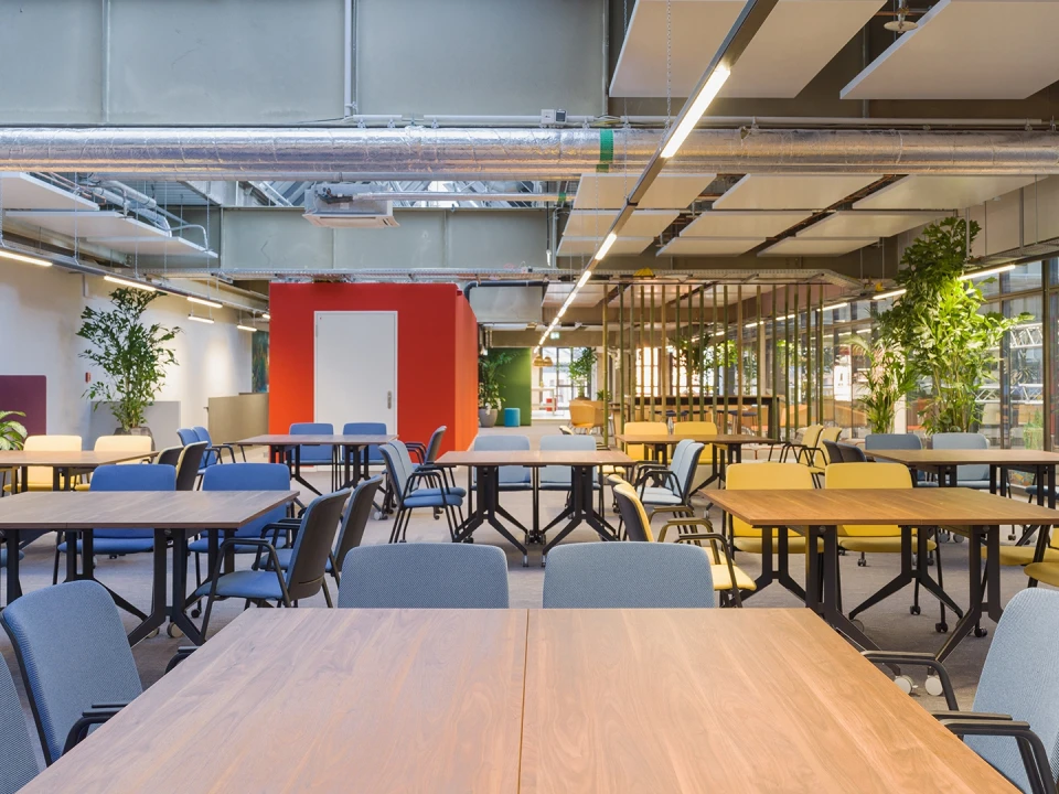 Bar and lounge area featuring a high table, refrigerators, wicker lampshades, and numerous plants.